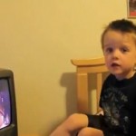 Little boy sitting on bed watching TV